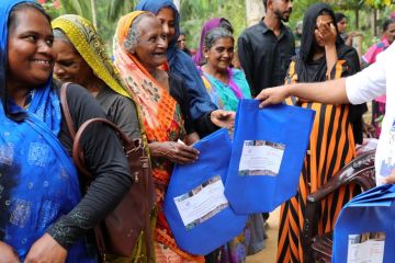 A row of community members smiling while receiving support packages from ESDF.