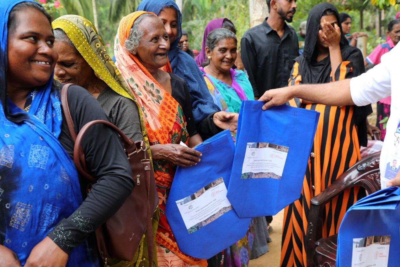 A row of community members smiling while receiving support packages from ESDF.