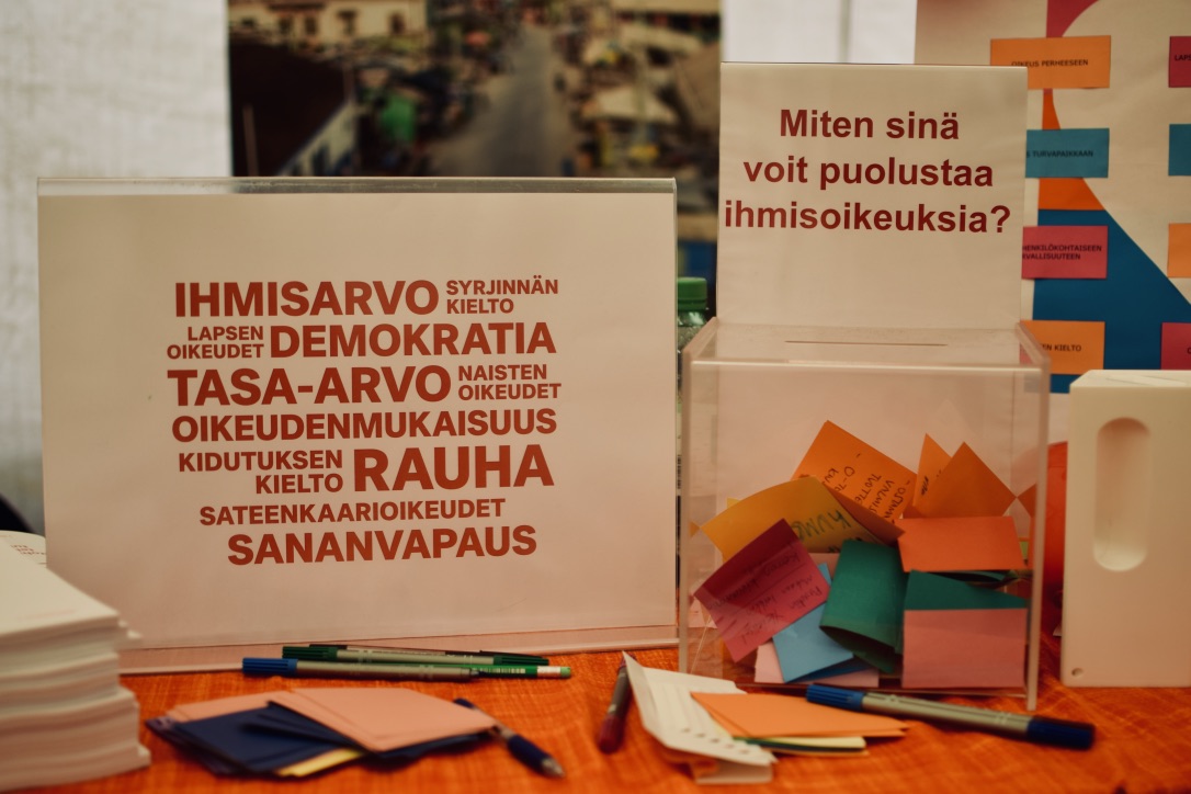 A box with colorful notes and a sign 
