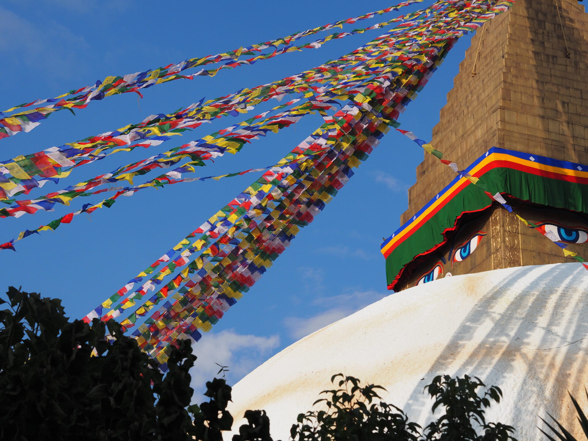 Boudhan stupa Kathmandussa, yksi Nepalin tärkeimmistä buddhalaisista pyhäköistä, kuvattuna kirkkaana päivänä rukouslippujen ympäröimänä.