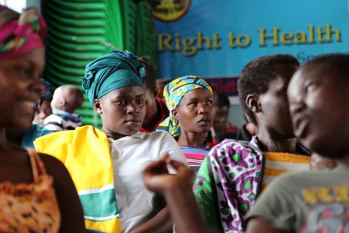 Ihmisiä ja taustalla teksti “right to health”